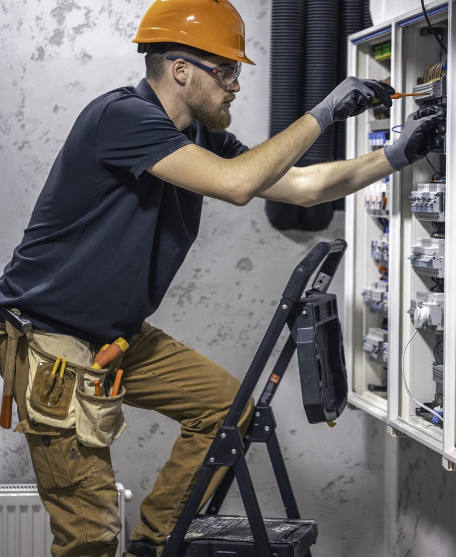 A male electrician works in a switchboard with an electrical connecting cable. Electrician with screwdriver tightens electrically operated switching equipment in fuse box. SSUCv3H4sIAAAAAAAACpySz26DMAzG75P2DijnIpXSANurVDuYJBSraVIlodNU9d2XP1B5193wz/ZnfzGP97eqYiN4FOyzeqQoxqj14oODgNZEvN+t3CkjlaPk7tpuTwEgjZTEYB2CpnCEIGYDVxWhWbRO+JmTzAcIi1c+7bIiAUGdo0aBL4my8KnE1ZbIydgRU4ztCPPLmNmGivi/OsvH18vwWRnxkxcmRpzSCoqRUylll++g3JVag0WiJa7uVoBOBS1RAryBgz99N4cCzZkQG+Z8l01J2MUEl7Z6mWHa2huMOr36FMeojc/gfSyXGyezRfwL7JXMMTZkT6sqk/E4KWzalvOh5d2eH3h/6A/DWlAOOmPUyetsQjEWF5TUFaYN2CCE6JrhWHd86OvjpJoaunGqoembj0lxKXsZb/H8BQAA//8DAN+Xh7m5AgAA